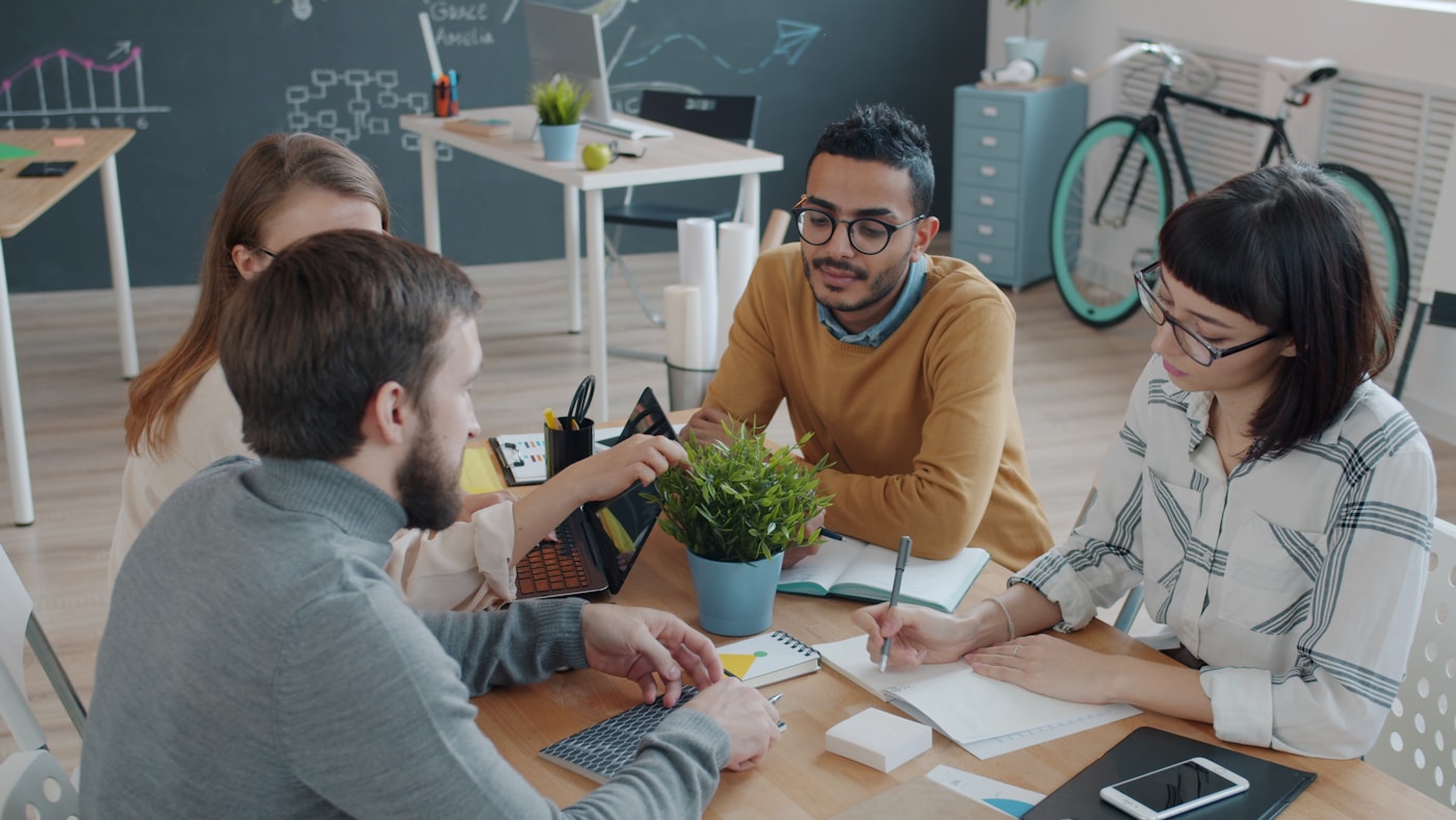 A diverse team collaborating around a table in a bright office